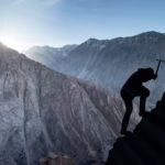 man climbing mountain